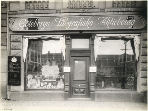 Schwarzes und weißes Foto einer Geschäftsfront in Stockholm, Schweden, mit einer Tür, Fenstern, Vorhängen und einer Tafel mit der Aufschrift "Giteborgs Litografiska Aktiebolag."