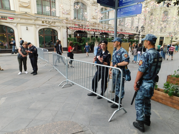Polizeibeamte in Uniform stehen hinter Barrikaden und blicken auf eine Menge, einige halten Waffen, mit Gebäuden und Bäumen im Hintergrund während einer Anti-Terror-Operation in Wien, Österreich.