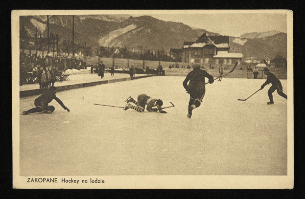 Schwarz-weißes Foto von Menschen, die Hockey auf einem Eisplatz spielen, mit Gebäuden, Bäumen, Pfählen und Bergen im Hintergrund, mit Text unten.