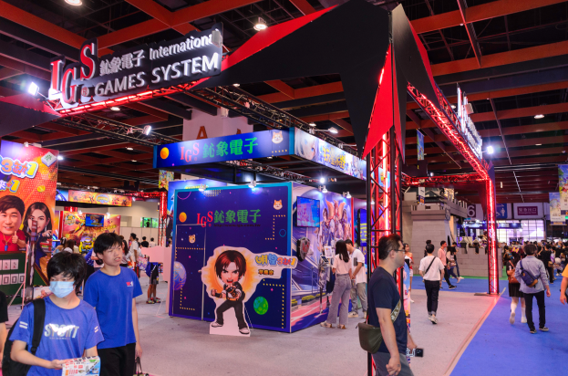Eine Gruppe von Menschen geht durch einen Convention-Saal auf einer Gaming-Messe in China, einige tragen Taschen und halten Gegenstände, mit Ständen, Lichtern und einem Teppichboden.