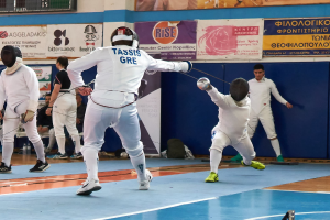 Gruppe von Fechtern in einer Turnhalle mit Helmen und Schwertern, einer Anzeigetafel oben, Bannern an der Wand und Zuschauern auf Stühlen.