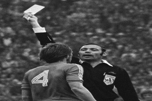Schiedsrichter in Schwarz-Weiß-Foto hält weiße Karte hoch vor Fußballspieler