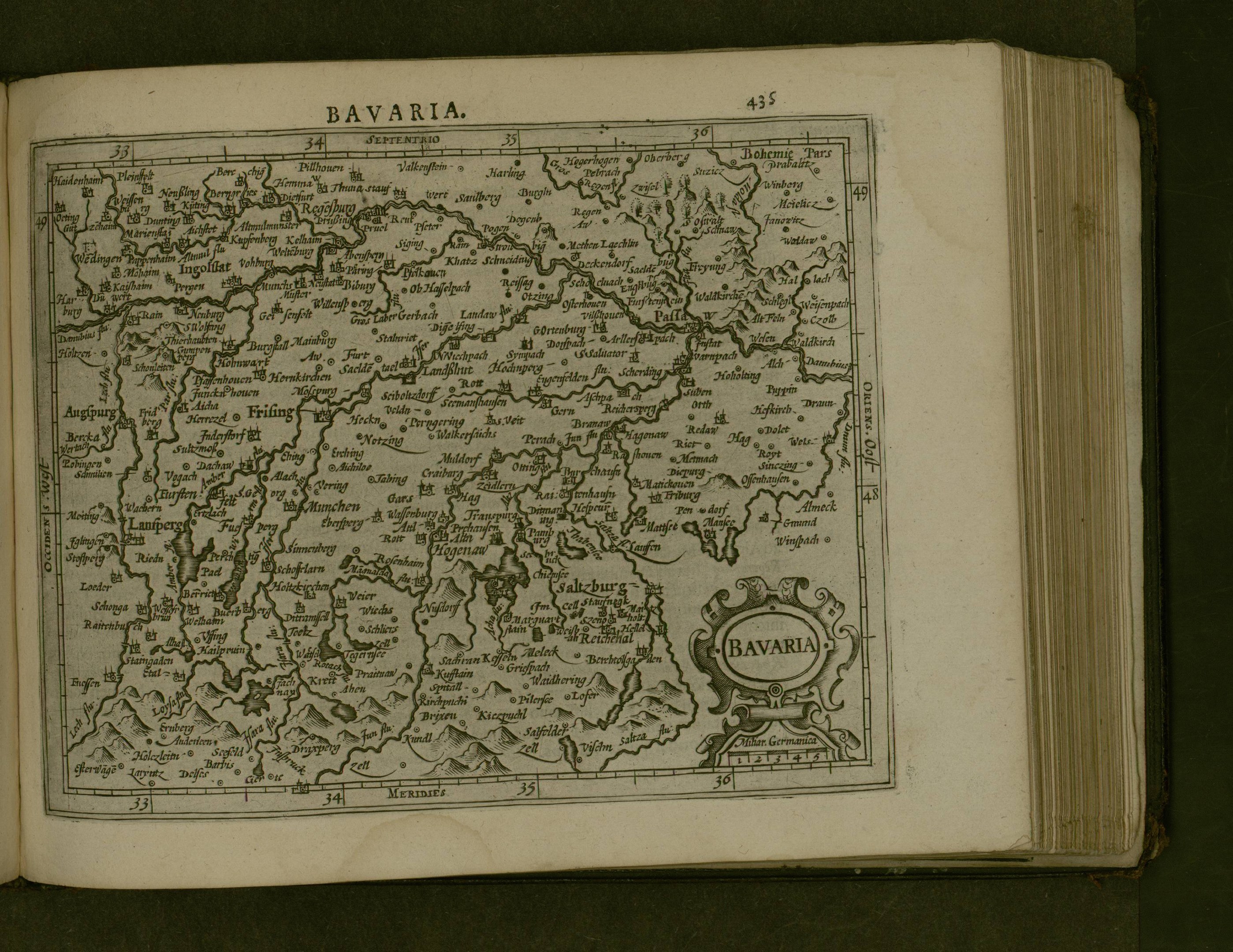 Ein aufgeschlagenes Buch mit einer detaillierten Karte von Bayern, auf der wahrscheinlich die Region und ihre Städte beschrieben werden.