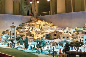 Ein detailliertes Modell einer Krippe in einem Museum, mit Figuren, Strukturen und Beleuchtung.