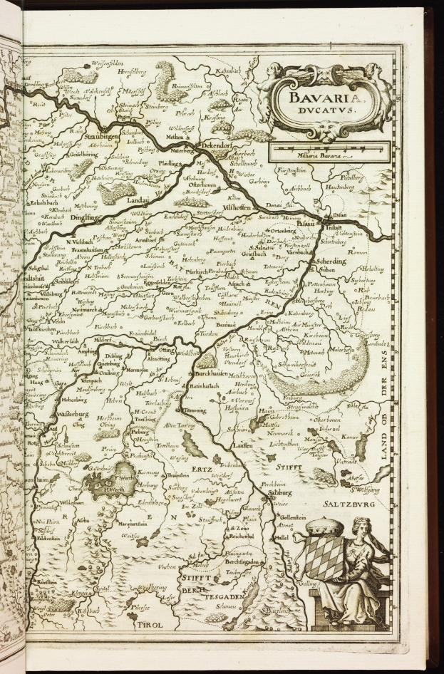 Ein aufgeschlagenes Buch mit einer detaillierten Karte von Bayern, das Städte, Ortschaften, Flüsse und andere geografische Merkmale zeigt, mit begleitendem Text, der zusätzliche Informationen liefert.