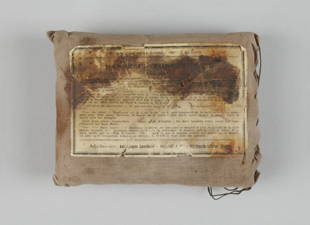 Eine kleine Notfall-Apotheken-Tasche mit einem Papier, auf dem Inhalt oder Anweisungen aufgeführt sind.