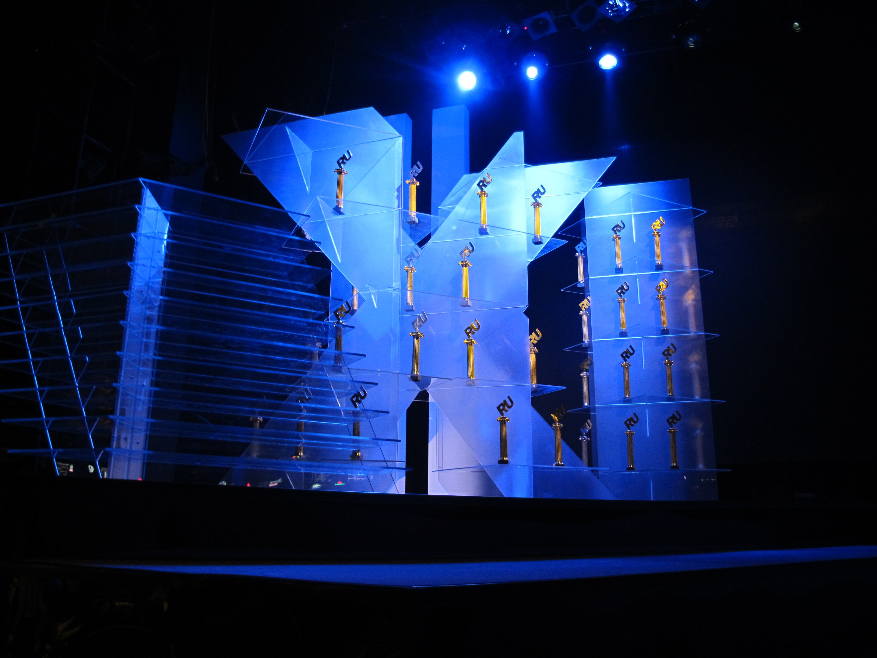 Bühne für eine Preisverleihung mit dunklem Hintergrund und minimaler Beleuchtung, mit wenigen Gegenstönden auf der Bühne.