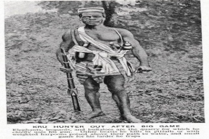 Schwarzes und weißes Foto eines Mannes, der draußen steht und eine Waffe hält, mit Bäumen im Hintergrund und Text unten, der "Kru Hunter Out After Big Game" lautet.