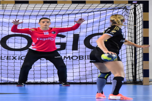 Zwei Frauen beim Handballspielen auf einem Platz, eine hält einen Ball, im Hintergrund ein Netz und eine Tafel mit der Aufschrift "Futsal-Weltmeisterschaft 2019".