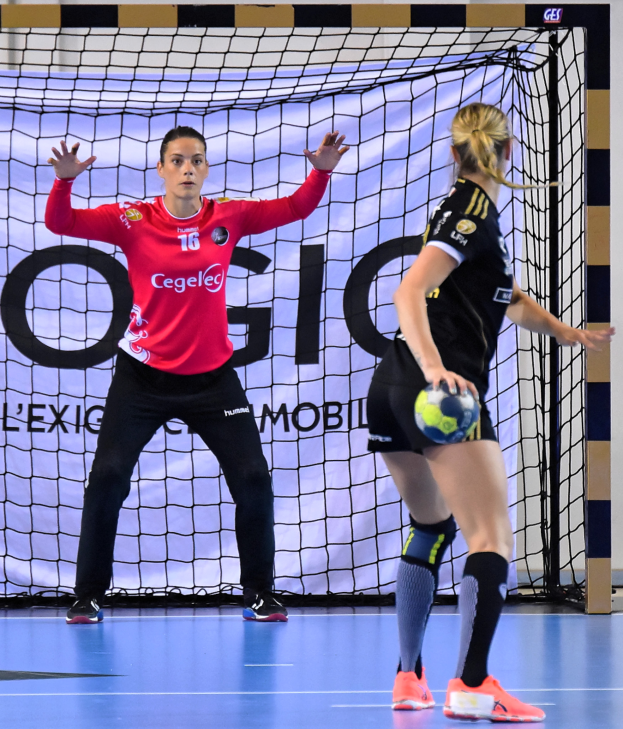 Zwei Frauen beim Handballspielen auf einem Platz, eine hält einen Ball, im Hintergrund ein Netz und eine Tafel mit der Aufschrift "Futsal-Weltmeisterschaft 2019".