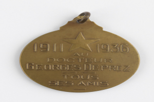 Goldene Medaille mit Stern, eingravierter Inschrift und weißem Hintergrund, wahrscheinlich zum Gedenken an einen Arzt.