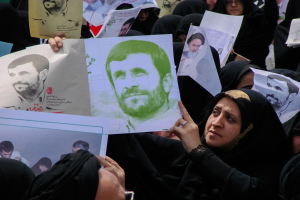 Gruppe iranischer Frauen in schwarzer Kleidung, die Fotos des Präsidenten Mahmoud Ahmadinejad während einer Kundgebung in Tehran hochhalten, einige tragen Brillen.
